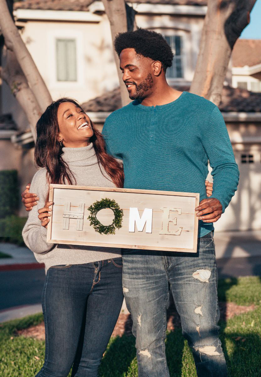 African-American-couple-holding-Home-sign